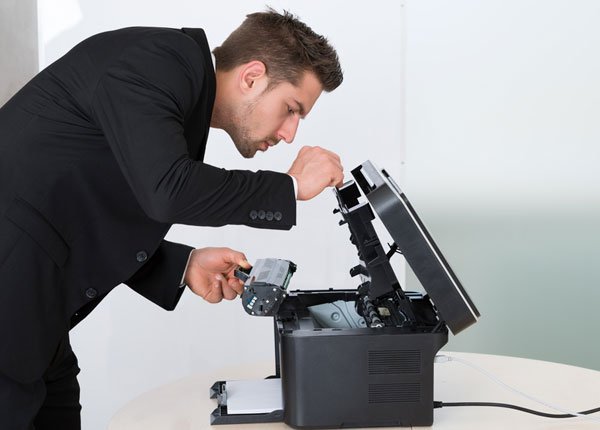 Man adding toner cartridge to printer