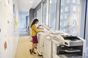 Full length of businesswoman using computer printer