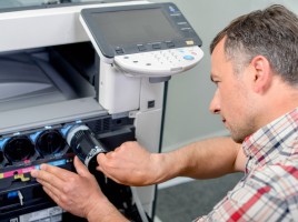 Man adding new toner cartridge to printer