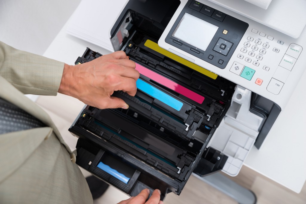 Man adding toner cartridge to printer