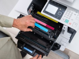Man adding toner cartridge to printer