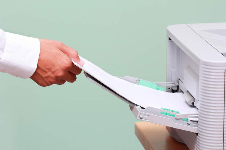 Man adding paper to printer