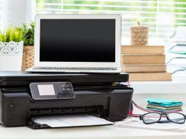 small printer with laptop on top of it