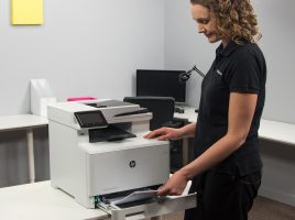Woman adding paper to printer paper tray