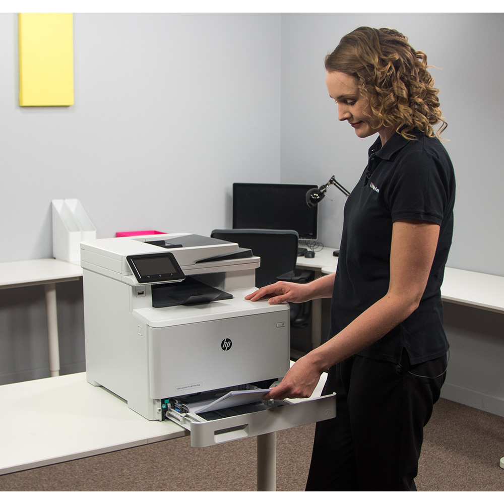 Woman adding paper to printer paper tray